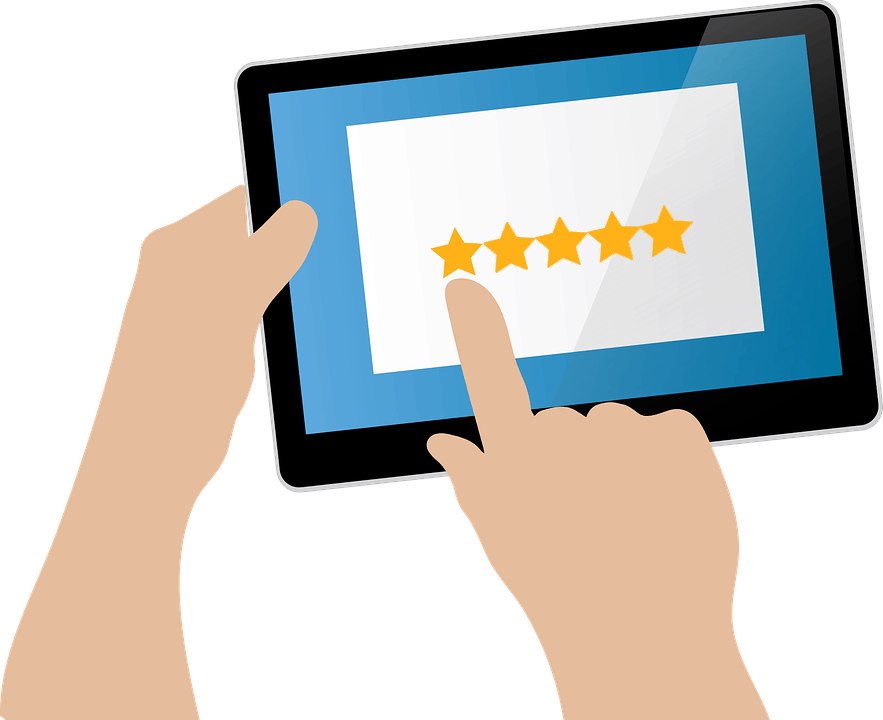 A person holding a tablet with both hands, using the right index finger to select a five-star rating on the screen. The background is white, and the stars are highlighted in gold, indicating a high rating.