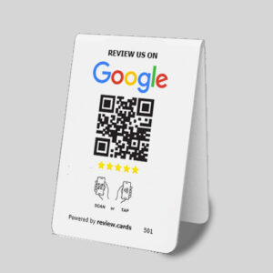 A Google Tap or Scan Table Tents card with a QR code and instructions to review on Google. It displays five stars, icons for scanning or tapping the QR code, and is supported by review.cards. The centered QR code has text above and below it. The background is gray. Perfect Google Tap or Scan Table Tents solution.