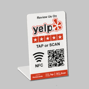 A Yelp Tap or Scan PoP Stands - FREE Delivery encouraging Yelp reviews. It shows the Yelp logo with five stars beneath it, the text "TAP or SCAN," an NFC symbol, and a QR code. "Powered by Review.cards" and icons for tap and scan are in the footer. Perfect for PoP stands, the background is gray.
